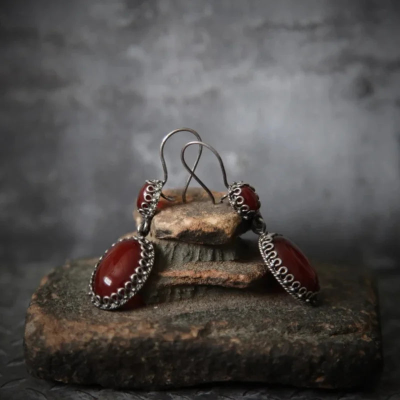 Brincos femininos vintage ovais com zircónias vermelhas incrustadas, estilo clássico e elegante, em tom de prata antiga.